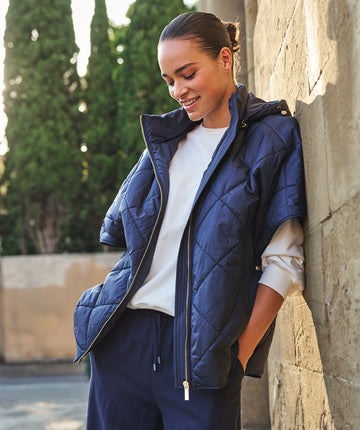 Quilted long poncho in a check pattern with zipper closure, hood, and snap buttons on both sides at the bottom.
Specifications
